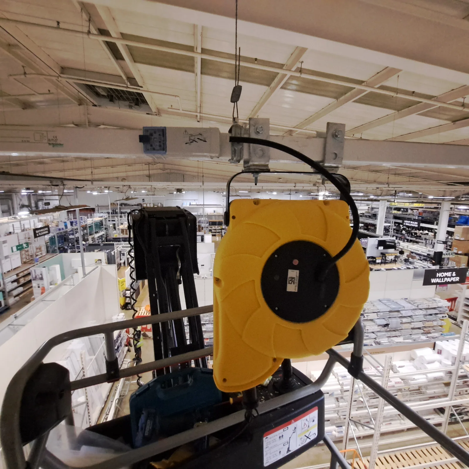 Retractable power reel mounted above a live retail floor